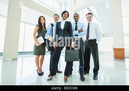 Geschäftsleute, die lächelnd im Büro lobby Stockfoto