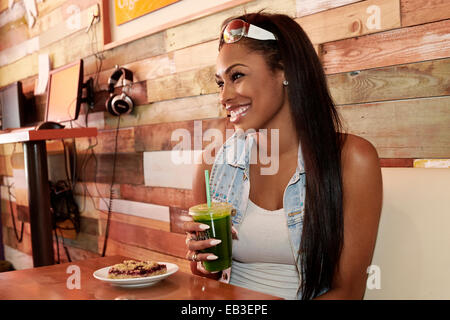 Afrikanische amerikanische Frau, die mit Saft im café Stockfoto