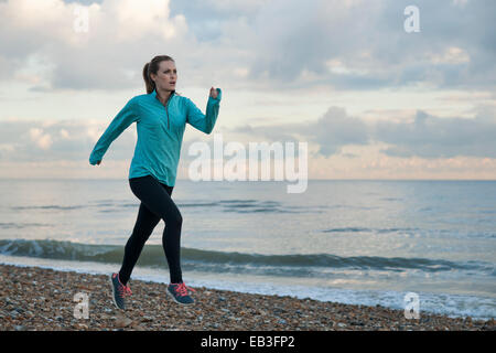 Junge Frau am Meer am Strand entlang laufen Stockfoto