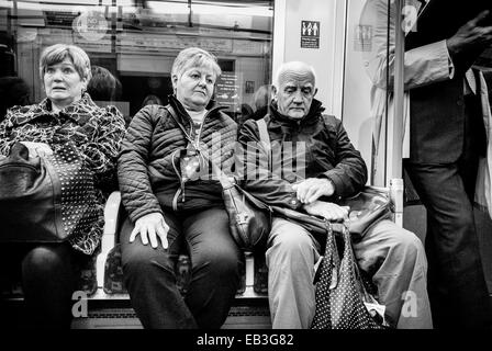 Drei reife kaukasische Erwachsene, die in einer U-Bahn sitzen. Stockfoto