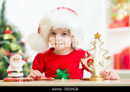 Kind Mädchen in Nikolausmütze mit Weihnachten Plätzchen Stockfoto