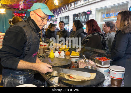 Glasgow, Schottland, Großbritannien. 25. November 2014. Mit ein Monat bis Weihnachten, die jährlichen Weihnachts Food Market, in diesem Jahr in die Argyle Street Glasgow gehalten wird jetzt jeden Tag geöffnet bis zum 21. Dezember 2014. Viele Weihnachtskäufer waren das Essen an den Ständen der internationalen Küche, darunter traditionelle Deutsche, Französische und Spanische Bistros und Take-away auf dem größten Weihnachtsmarkt, Glasgow immer bewirtet hat. Credit: Findlay/Alamy leben Nachrichten Stockfoto