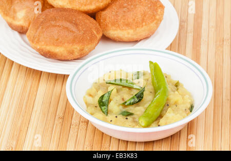 Köstliche tiefe gebratenen Poori (Puri) serviert mit pikanten Kartoffel Zwiebel Curry (Saagu). Stockfoto