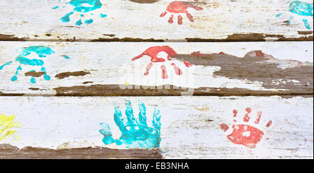 Hand druckt in roter und blauer Farbe auf eine weiße Holzoberfläche Stockfoto