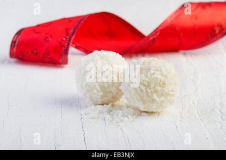 Kokos-Schneeball-Trüffel auf weißem Hintergrund. Anordnung der Kokosnuss-Cookies auf hölzernen eleganten Hintergrund. Stockfoto