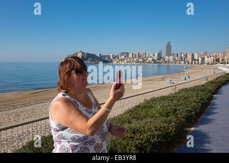 Benidorm, Costa Blanca, Spanien, Europa. Frau touristische Promenade, mit Handy, Handy Selfie selfy übernehmen. Stockfoto