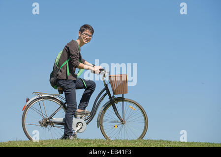 Porträt des jungen männlichen Studenten mit einem Fahrrad im park Stockfoto