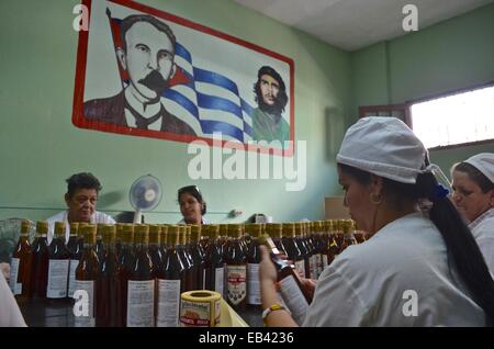 Arbeitnehmer-Label und Pack Flaschen am Ende einer Fertigungsstraße in rum Destillerie in Pinar del Rio, Kuba Stockfoto