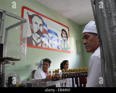 Arbeitnehmer-Label und Pack Flaschen am Ende einer Fertigungsstraße in rum Destillerie in Pinar del Rio, Kuba Stockfoto