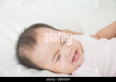 Süße Asiatin Baby weint im Bett Stockfoto