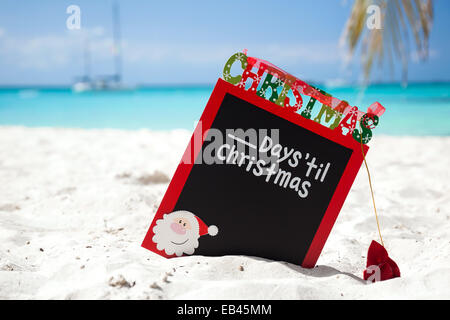 Weihnachten-Board am weißen Sandstrand, mit Inschrift - einen Tag bis Weihnachten, Tourismus-Konzept Stockfoto