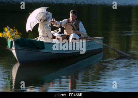 Ein paar romantische viktorianische genießen Sie eine Flasche Wein in einem Ruderboot Stockfoto