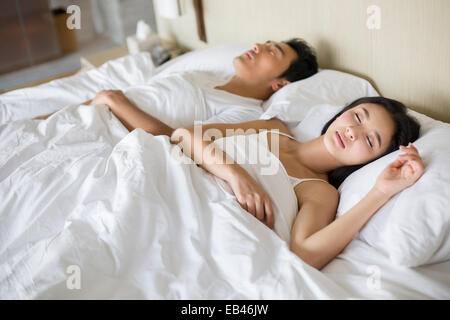 Junges Paar schläft auf Bett Stockfoto