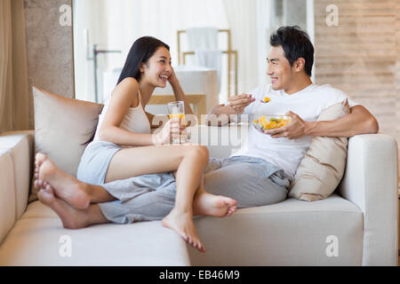 Glückliches junges Paar sitzt auf dem sofa Stockfoto