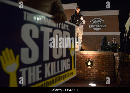 Ferguson, USA. 25. November 2014. Demonstranten an einen Protest außerhalb Ferguson Polizeistation, St. Louis County, Missouri, Vereinigte Staaten von Amerika, 25. November 2014 teilnehmen. Mehr als 1.500 Truppen der Nationalgarde trat etwa 700 Gardisten, die bereits auf der Bühne gegen lokale Gesetze Durchsetzung schützen Bewohner und Eigentum in Ferguson, einen Tag nach eine Grand Jury zur hand eine Anklage gegen Ferguson Polizeibeamten Darren Wilson,, die abgelehnt erschießt unbewaffneten Teenager Michael Brown im August zu helfen. Bildnachweis: Yin Bogu/Xinhua/Alamy Live-Nachrichten Stockfoto