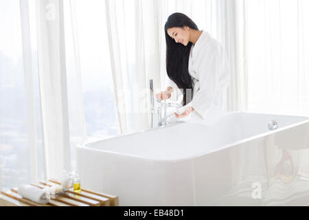 Junge Frau Füllung Badewanne Stockfoto
