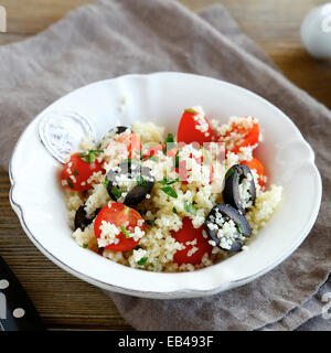 Couscous-Salat mit Gemüse und Oliven in weißer Teller, Essen Nahaufnahme Stockfoto