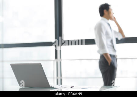 Junger Geschäftsmann reden über Handy im Büro Stockfoto