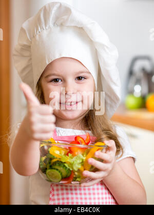 kleines Mädchen gesundes Essen zubereiten und Daumen auftauchen Stockfoto