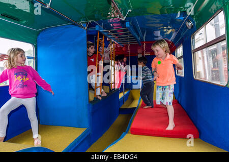 Kinder spielen auf einem Doppeldecker-Bus in eine Geburtstag Partylocation für gymnastische Aktivitäten umgewandelt. Stockfoto