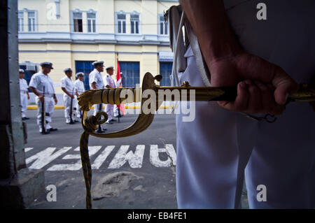 Ein peruanische Marine-Offizier in uniform Kleid steht eine zeremonielle Schwert hält. Stockfoto