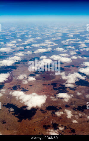 Eine Flottille von weißen flauschigen Wolken Schatten auf eine weite Wüstenebene. Stockfoto