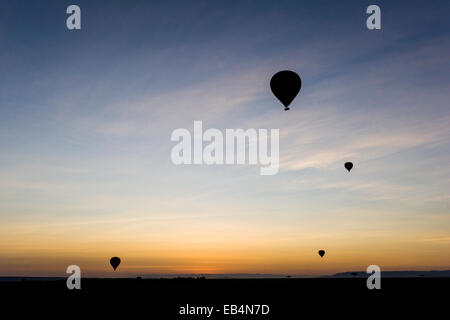 Die Silhouette des Heißluftballons steigen in den Himmel vor Sonnenaufgang über der dunklen afrikanischen Savanne-Ebene. Stockfoto