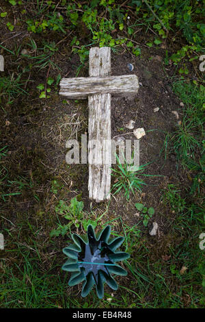 Altes Holzkreuz auf Boden Kennzeichnung Grab gelegt Stockfoto