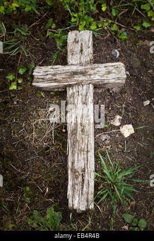 Altes Holzkreuz auf Boden Kennzeichnung Grab gelegt Stockfoto