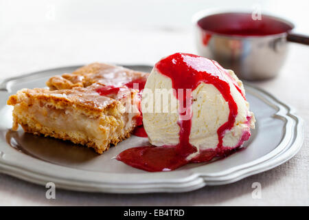 Apfelkuchen mit Vanilleeis und Himbeersauce Stockfoto