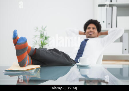 Geschäftsmann in seinem Drehstuhl mit Füßen, entspannende Stockfoto
