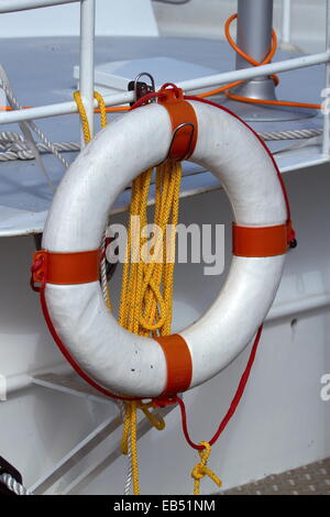 Rettungsring und Seil hängen von der Reling eines Bootes Stockfoto