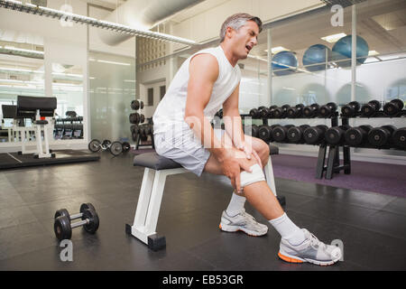 Verletzte sein Knie in den Kraftraum greifen Stockfoto