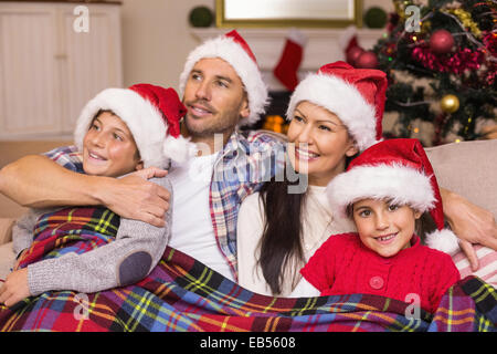 Happy Family im Santa Hut umarmt unter der Abdeckung Stockfoto