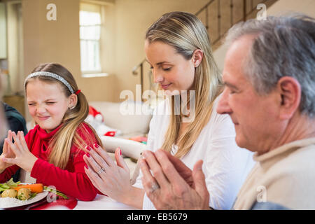 Großfamilie sagen Gnade vor dem Weihnachtsessen Stockfoto