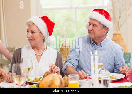 Niedlich älteres Paar in Nikolausmütze Weihnachten Abendessen Stockfoto
