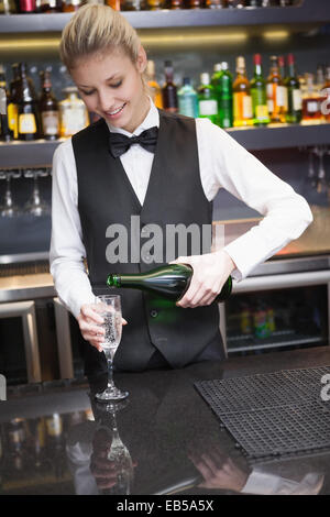 Nette Frau im Anzug Gießen Champagner in Querflöte Stockfoto