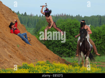 Indischen Krieger Angriffe mit einem Tomahawk auf Cowboy (рarticipant role-playing Game) Stockfoto