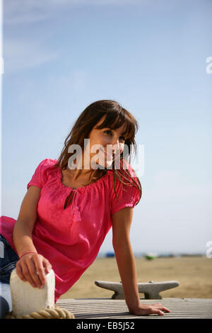 Frau setzte sich auf der Promenade Stockfoto