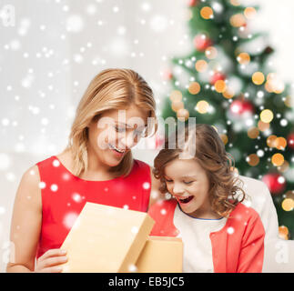 Lächelnde Mutter und Tochter mit Geschenk-Box zu Hause Stockfoto