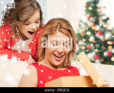 Lächelnde Mutter und Tochter mit Geschenk-Box zu Hause Stockfoto