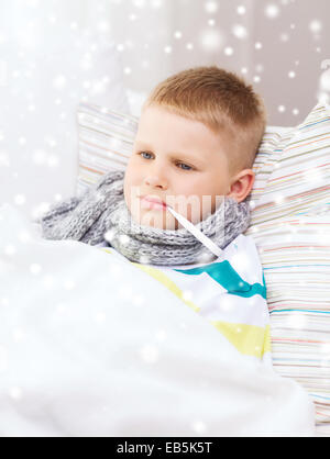 krank junge mit Thermometer im Bett zu Hause Stockfoto