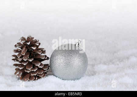 Hintergrund-Weihnachts-Dekoration mit Christbaumkugel, Tanne Kegel und Schnee Stockfoto