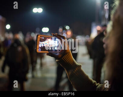 Ferguson, Missouri, USA. 25. November 2014. Eine Frau zeichnet Polizei vor der Ferguson-Polizei-Abteilung mit ihrem Handy Dienstagabend Proteste nach dem Darren Wilson Grand Jury Urteil weiter. Zehntausende von Menschen in 90 Städten der USA statt Kundgebungen am Dienstag gegen einer Grand Jury die Entscheidung nicht zu einen weißen Offizier anzuklagen, der eine schwarze Teen im Ferguson Missouri erschossen zu protestieren. Bildnachweis: Zach Roberts/ZUMA Wire/ZUMAPRESS.com/Alamy Live-Nachrichten Stockfoto