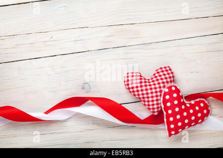 Valentinstag Hintergrund mit Spielzeug Herzen und Bändern über weißen Holztisch Hintergrund Stockfoto