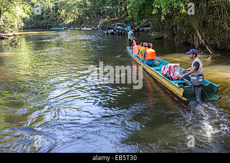 Touristen in Longboat gehen zu den Höhlen flussaufwärts am Melinau Fluss von Mulu Nationalpark, Malaysia Stockfoto