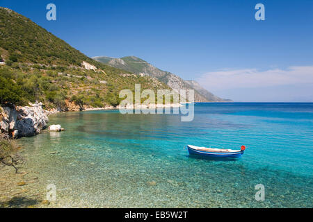 Vathy, Ithaka, Ionische Inseln, Griechenland. Blick vom Ufer über das türkisfarbene Wasser des Golfs von Molos, kleines Boot vor Anker. Stockfoto