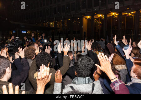 London, 26. November 2014. Eine Mahnwache für Teenager Mike Brown, der von einem Polizisten in Ferguson, Missouri in diesem Jahr erschossen wurde erfolgt außerhalb der US-Botschaft in London. Anti-Rassismus und Menschenrechte Aktivisten namens den "Notfall" Protest nach einem Gerichtsurteil, das Polizisten Darren Wilson des Mordes löscht. Bild: Das Publikum macht eine "Hands Up! Don't shoot! "Geste aus Protest gegen die Polizei Shootings. Bildnachweis: Paul Davey/Alamy Live-Nachrichten Stockfoto