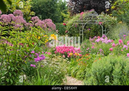 Joe - pye Unkraut (eupatorium), Garten Phlox (Phlox paniculata) und Rose (rosa) mit Garten Pavillon. Design: Marianne und Detlef lüdke Stockfoto