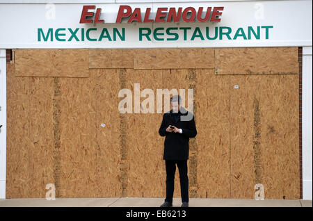 Ferguson, USA. 26. November 2014. Ein Mann steht vor einem Restauant, deren Fenster in Ferguson, St. Louis County, Missouri, USA, 26. November 2014 gebrochen wurden. Ferguson Gesichter Unruhen als Thanksgiving Urlaub Ansätze. Bildnachweis: Yin Bogu/Xinhua/Alamy Live-Nachrichten Stockfoto